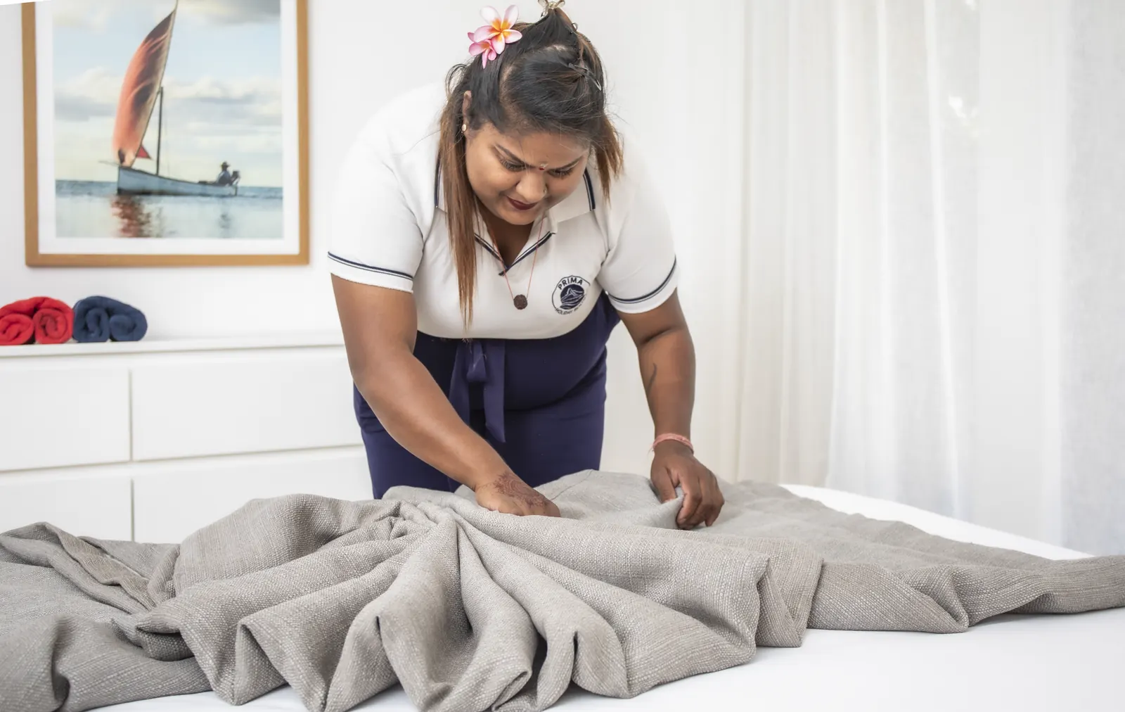 Une membre de l’équipe plie des serviettes sur un lit.