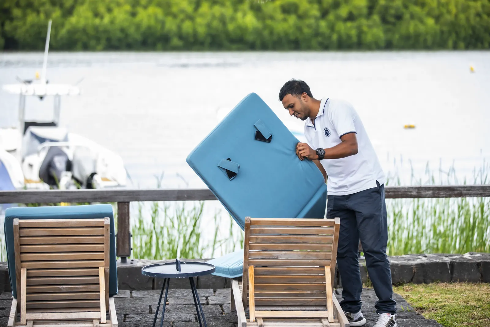 Un membre de l’équipe nettoie du mobilier extérieur.